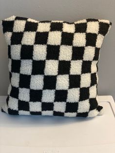 a black and white pillow sitting on top of a washer