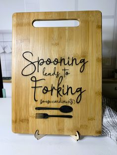 a wooden cutting board that says, spooning leads to forking some community on it