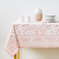 a table topped with plates and cups next to a vase