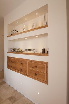 the shelves are made out of wood and have various items on them, including cups