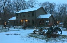 a house with lights on in the snow