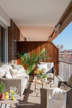 a balcony with wicker furniture and potted plants