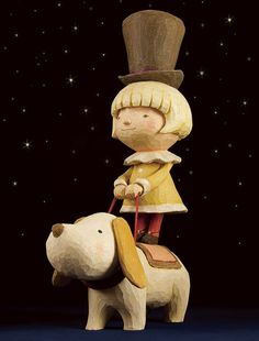 a wooden statue of a boy riding on top of a dog with stars in the background