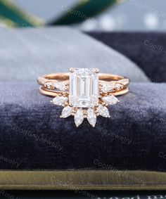 an emerald cut diamond ring on top of a velvet cushion