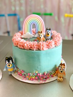 a birthday cake with frosting and cartoon characters on the top, sitting on a table