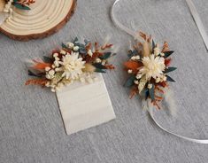 two pieces of fabric with flowers and feathers on them next to a piece of ribbon