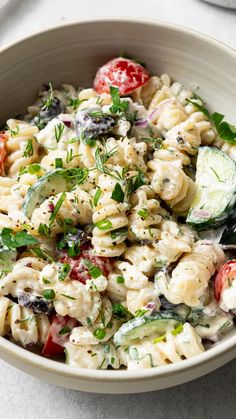 a white bowl filled with pasta salad on top of a table