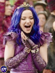 a woman with blue hair is laughing and holding her hands in her mouth while wearing purple gloves