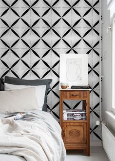 a bedroom with black and white geometric wallpaper