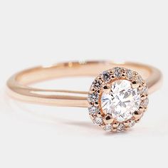 a rose gold ring with an oval diamond center surrounded by small white and brown diamonds