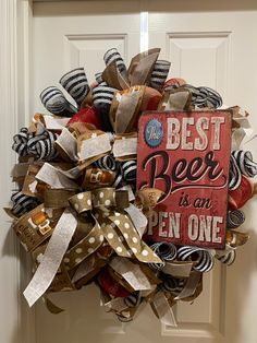 a wreath with the words best beer is an open one hanging on a front door