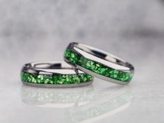 two wedding bands with green glitter on them