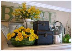 yellow flowers are in a basket on the mantle