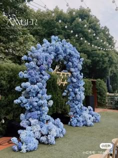 blue hydrangeas are arranged in the shape of an o'letter for a wedding ceremony