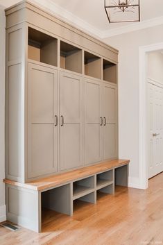 an empty room with some wooden shelves and drawers on the wall next to a light fixture