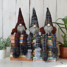 three gnomes are sitting on top of some books