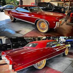 an old red car with gold rims parked in front of other cars on the street