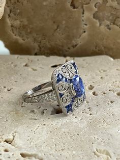 Item Details Model Number: SDL3500BWY Metal: Platinum 850 Weight: 9.1 grams Length: 18 mm (face of ring) Width: 18 mm (face of ring) Style: Art Deco Ring Size: 6.5 (contact us for sizing options) Main Stone Details Main Stone: Sapphire Carat Weight: 3.87 CT, 0.85 CT Shape: Oval, French Cut Color/Clarity: Blue/ Certificate: GGA All of our diamonds and gemstones are 100% natural! Other Diamond Details Carat Weight: 0.85 CT Shape: Round Color/Clarity: F/SI1 Cut: Excellent Blue Certificate, Style Art Deco, Platinum Diamond Rings, French Cut, Studded Necklace, Eternity Band Ring, Deco Ring, Deco Jewelry, Platinum Ring