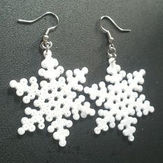 white snowflake earrings on black surface