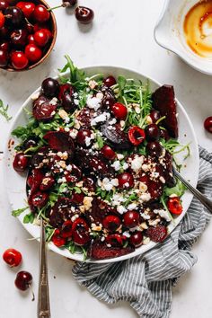 a white bowl filled with cherries and feta cheese on top of a table