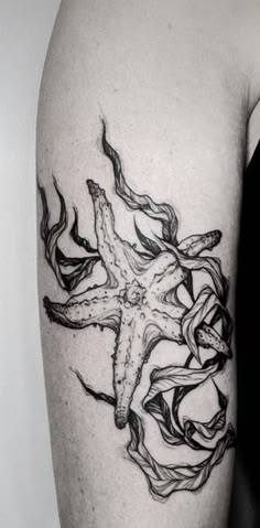 a black and white photo of a starfish tattoo on the right upper half of a woman's arm