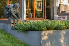 a statue of an elephant is in the middle of a planter outside a house