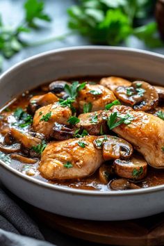 chicken and mushroom stew in a white bowl on a wooden cutting board with parsley