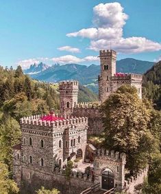 an aerial view of a castle with mountains in the background