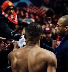 a man with no shirt standing in front of a crowd