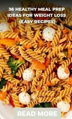 a bowl filled with pasta and vegetables on top of a table