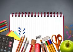 an apple, pencils, ruler, calculator and other school supplies on a desk