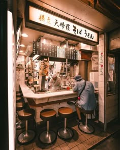 a person sitting at a counter in front of a restaurant