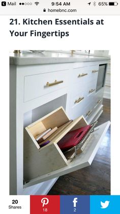 an open drawer on the side of a white kitchen counter with drawers and other items in it