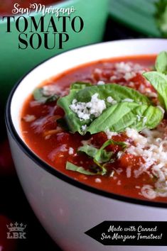 a bowl of tomato soup with spinach leaves and feta cheese in the middle