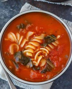 a bowl filled with pasta and spinach soup