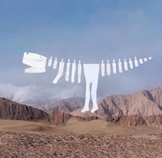 clothes hanging on a line in the desert with mountains in the background and snow - capped peaks