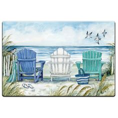 three chairs sitting on top of a beach next to the ocean with seagulls flying above