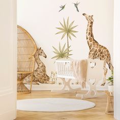 a baby's room with giraffes and plants on the wall