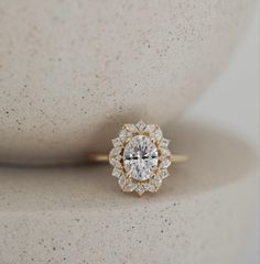 a close up view of a diamond ring on a white surface with the center stone surrounded by smaller diamonds