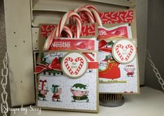 two bags with candy canes in them sitting on a shelf next to a window