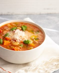 a white bowl filled with soup on top of a napkin