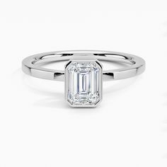 an emerald - cut diamond ring on a white background