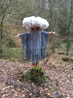 a scarecrow is standing in the woods with his arms outstretched