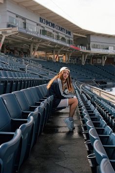 a woman sitting on the bleachers at a stadium