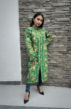 Get a polish look with this jacket. Pair it up with a skirt, trousers, dress or even a flowing maxi and be ready in style.Product Details- Condition: Brand New (made to order)- Handmade- Style: Coat- Fabric: Art Raw Silk/Pure Raw Silk/Wool- Embroidery: Kashmiri Aari Embroidery- Base Color: Green- Embroidery Color: Multi-Color- Fully Lined from Inside- Features Pockets on both sides- Length: 42" (107 cms approx)- Care Instructions: Dry Clean Only**If you want the coat to be shorter or longer, sen