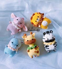 small crocheted animals sitting on top of a white sheet