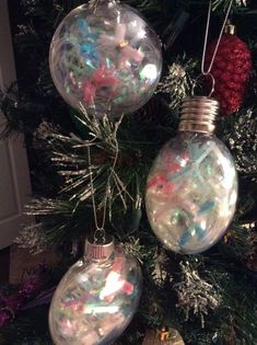 three ornaments are hanging from the christmas tree