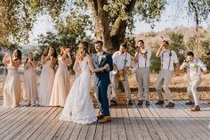 a group of people standing around each other on a wooden floor next to a tree