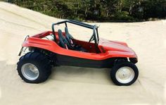 a red and black dune buggy on sand dunes