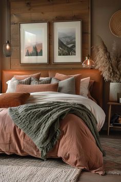 a bed with two pictures on the wall above it, and an orange comforter